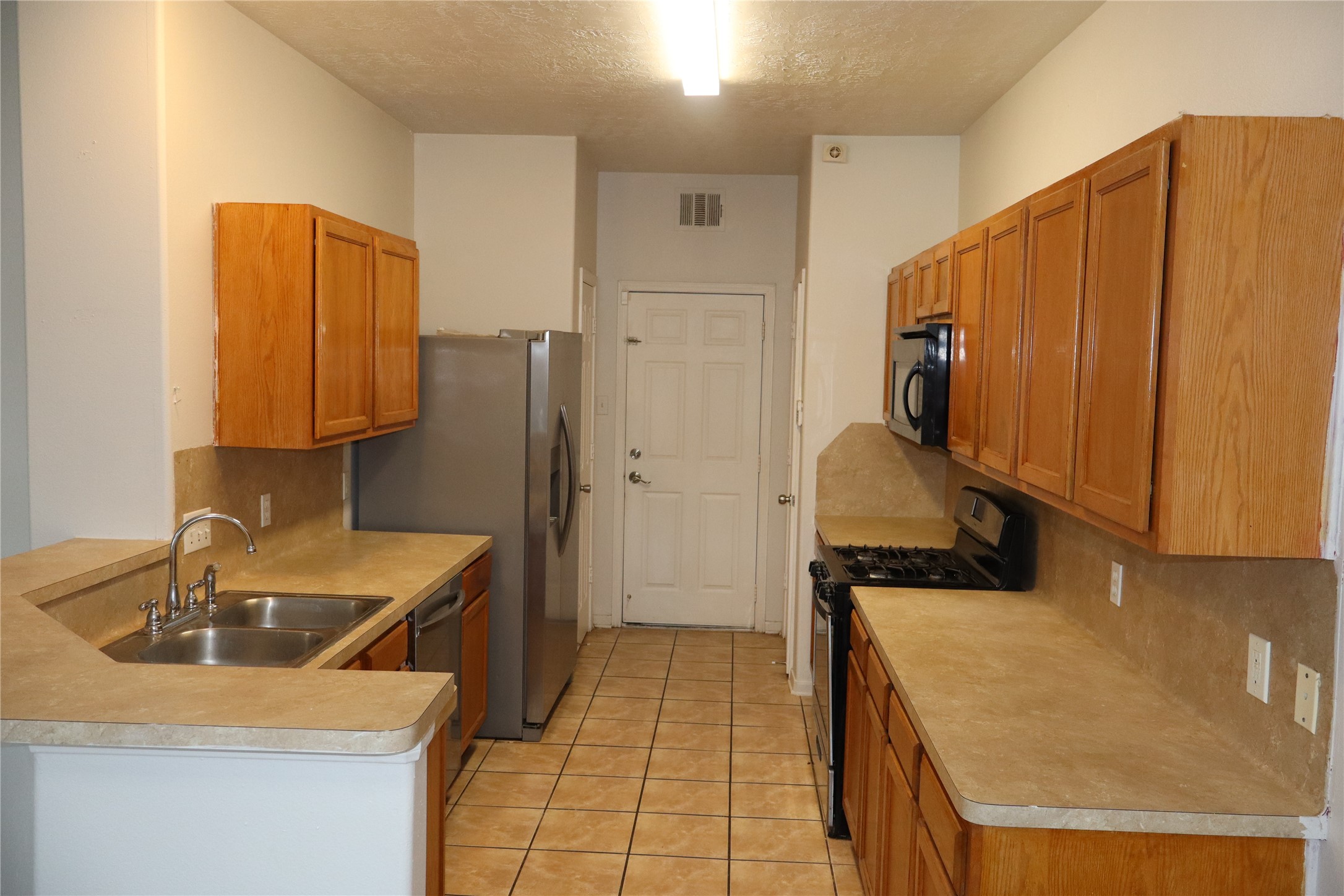 15931 Winston Point Lane Houston, TX 77084 - Photo 6 of 15 a kitchen with a sink a stove and a refrigerator