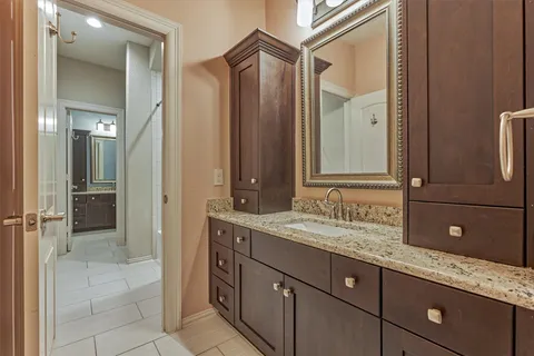 a bathroom with a granite countertop sink and a mirror