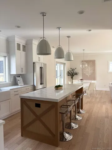a kitchen with stainless steel appliances a dining table chairs and wooden floor