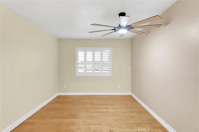 an empty room with windows and fan
