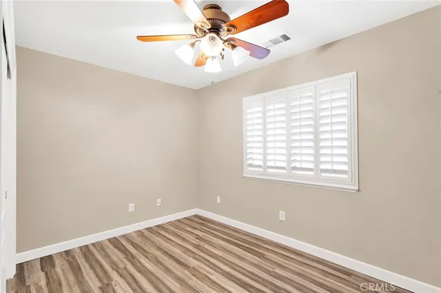 an empty room with a window and a fan