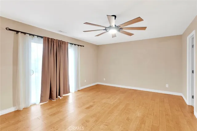 an empty room with windows and fan view