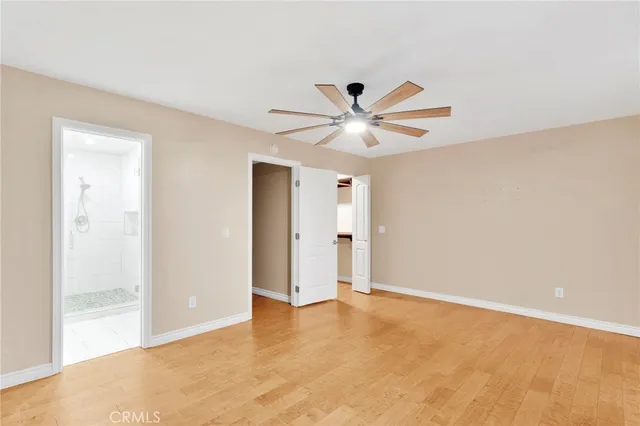 an empty room with a ceiling fan and window