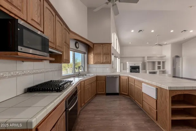 a kitchen with stainless steel appliances kitchen island granite countertop a stove and a sink