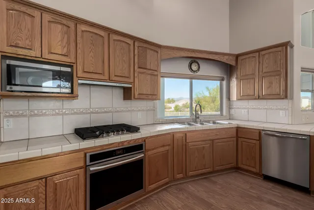 a kitchen with stainless steel appliances granite countertop a sink stove and cabinets