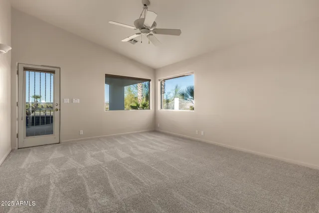 an empty room with windows and fan