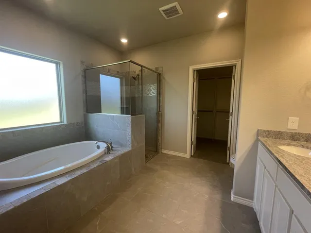 a bathroom with a tub sink and mirror