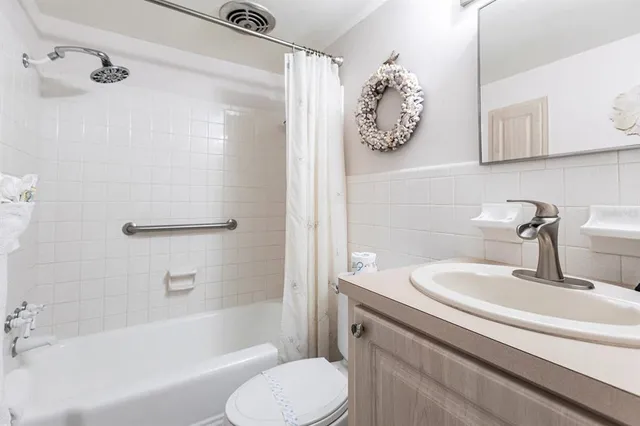 a bathroom with a granite countertop sink toilet and bathtub