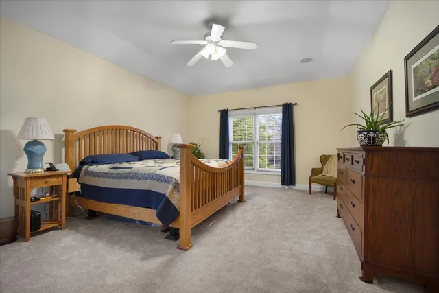 a spacious bedroom with a bed and a chandelier