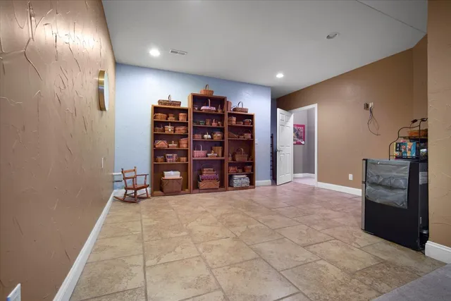 a view of an empty room with kitchen and a window