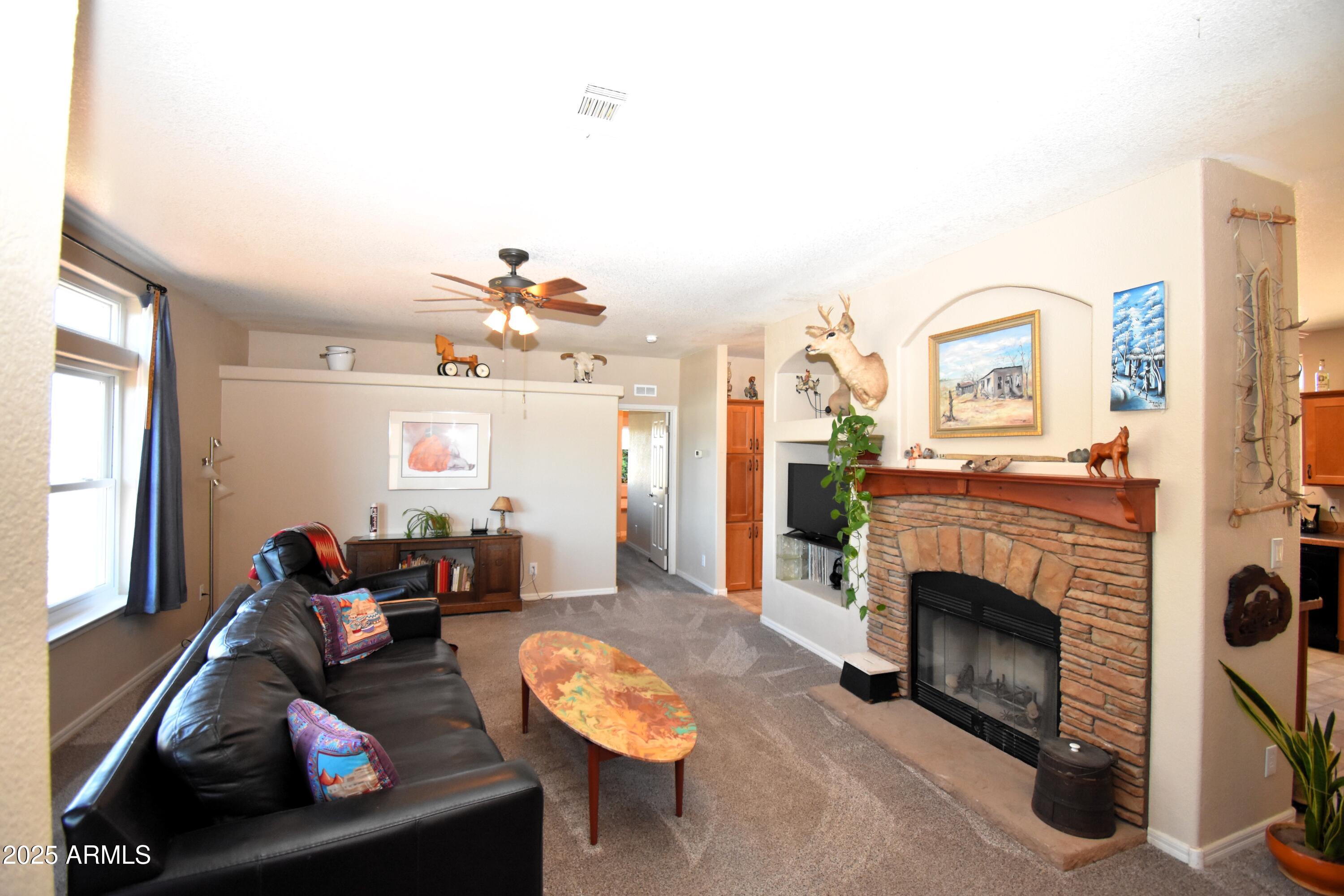 4665 Lazy Lariat Lane Rimrock, AZ 86335 - Photo 2 of 29 a living room with furniture a window and a fireplace