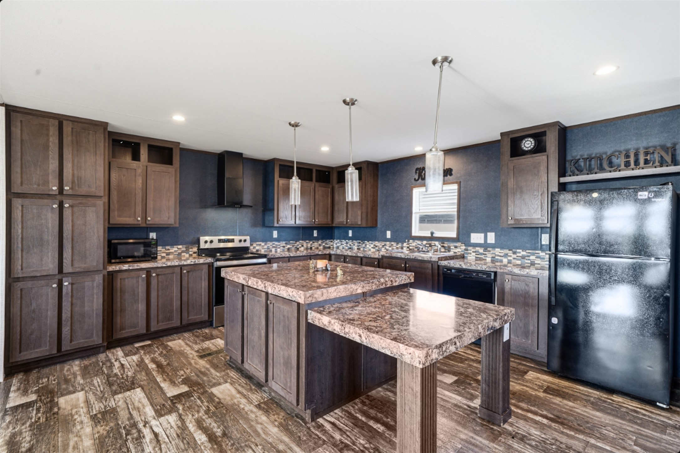 2493 County Road 464 Elgin, TX 78621 - Photo 10 of 40 a kitchen with a refrigerator a sink and a stove top oven with wooden floor