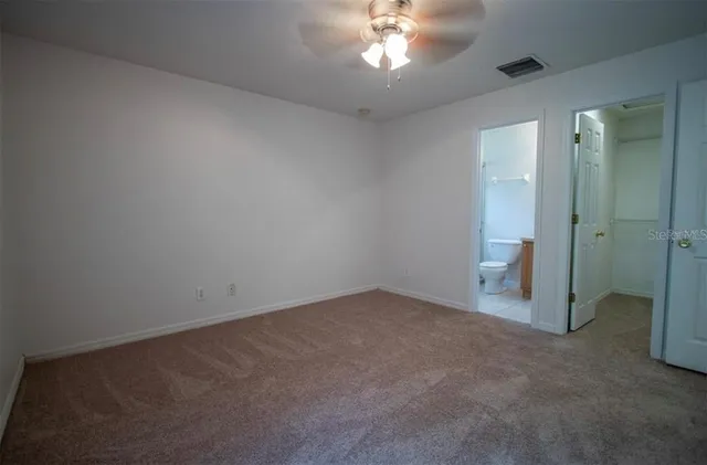 a bathroom with a granite countertop toilet a sink and a mirror