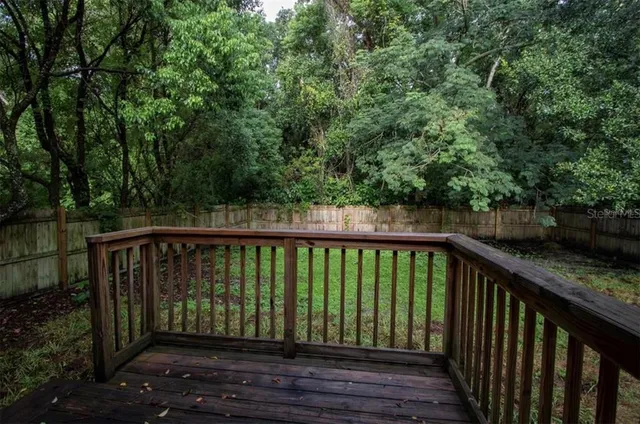a view of a backyard with wooden fence and a couple of plants