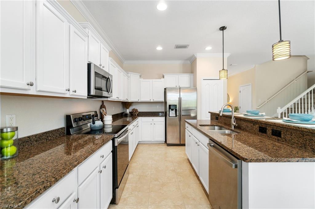 21017 Bella Terra Boulevard Estero, FL 33928 - Photo 11 of 45 a kitchen with stainless steel appliances granite countertop a sink a stove and a wooden floors