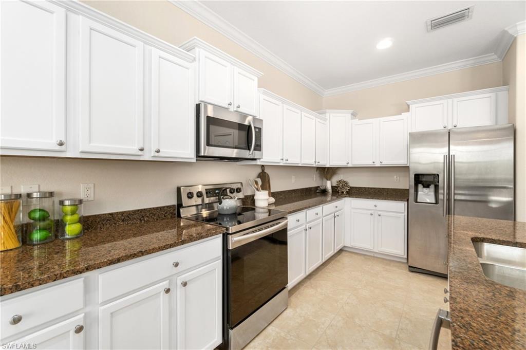 21017 Bella Terra Boulevard Estero, FL 33928 - Photo 12 of 45 a kitchen with granite countertop white cabinets stainless steel appliances and a counter space
