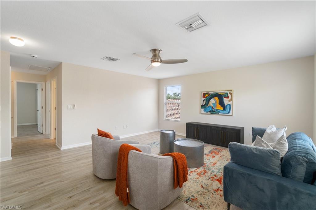 21017 Bella Terra Boulevard Estero, FL 33928 - Photo 21 of 45 a living room with furniture and a wooden floor