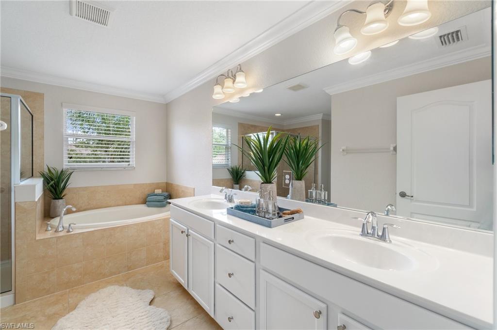 21017 Bella Terra Boulevard Estero, FL 33928 - Photo 24 of 45 a bathroom with a bathtub a double vanity sink and a large mirror
