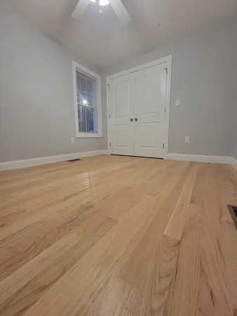 a view of an empty room with wooden floor
