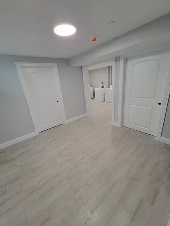 a view of empty room with wooden floor