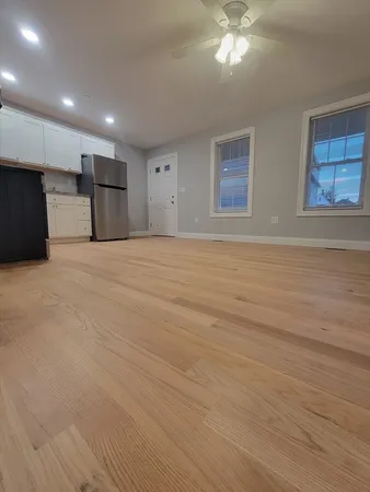 a view of a livingroom with a ceiling fan window and wooden floor
