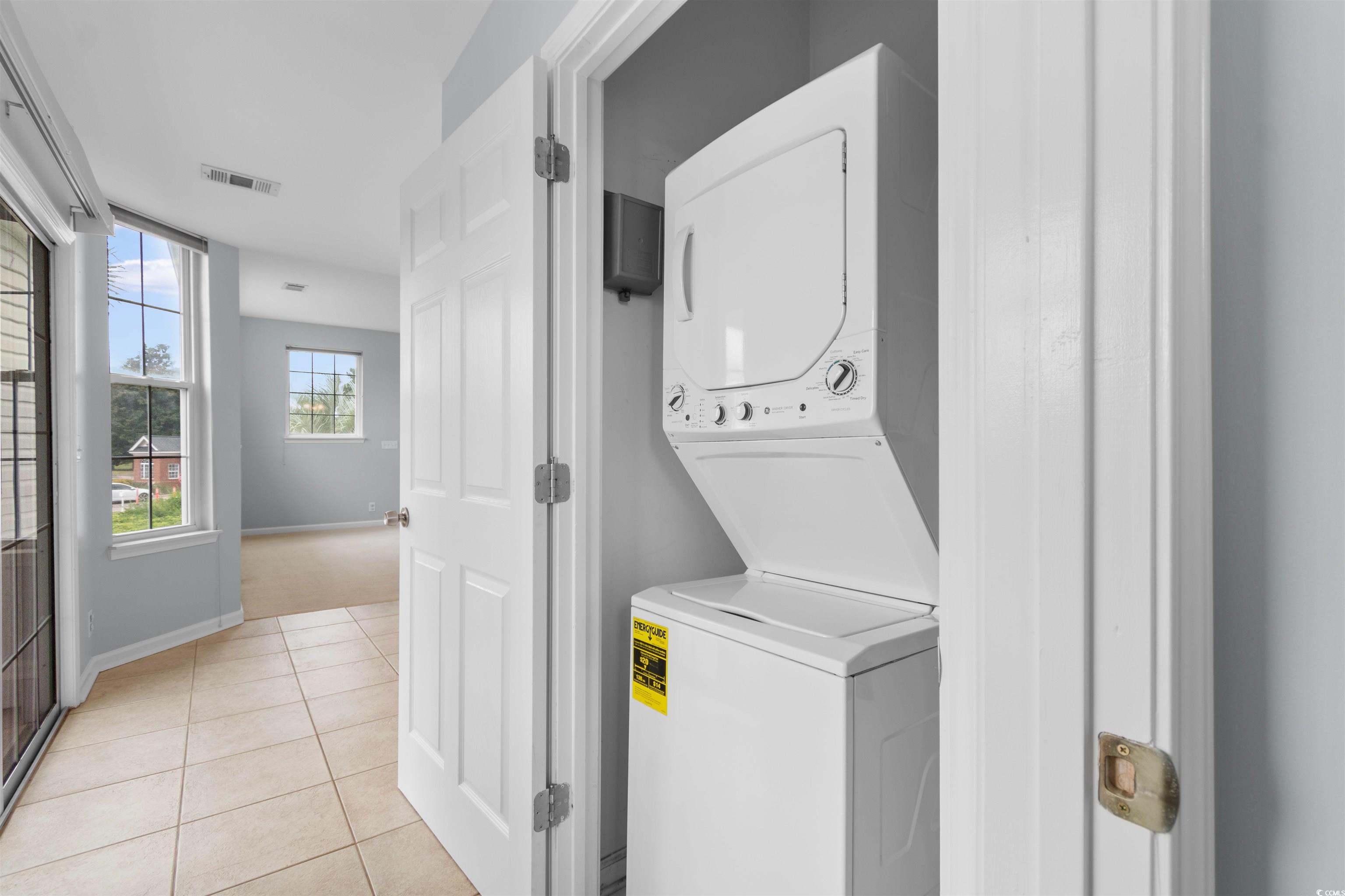 4430 Lady Banks Lane, Unit A2 Murrells Inlet, SC 29576 - Photo 24 of 31 Laundry area featuring stacked washing machine and dryer and light tile patterned flooring