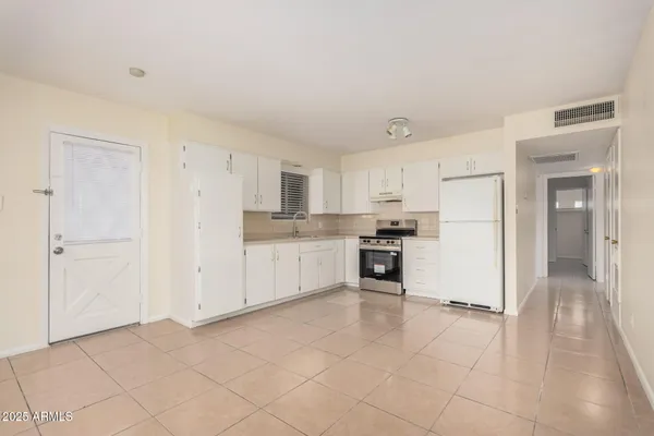 a kitchen with white cabinets and white appliances