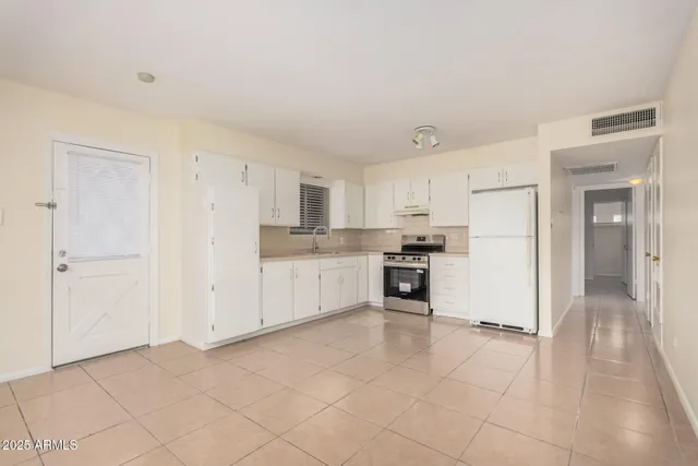 a kitchen with white cabinets and white appliances