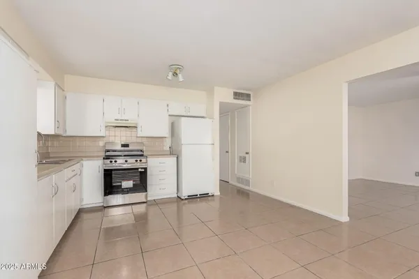 a kitchen with granite countertop a refrigerator and a stove top oven