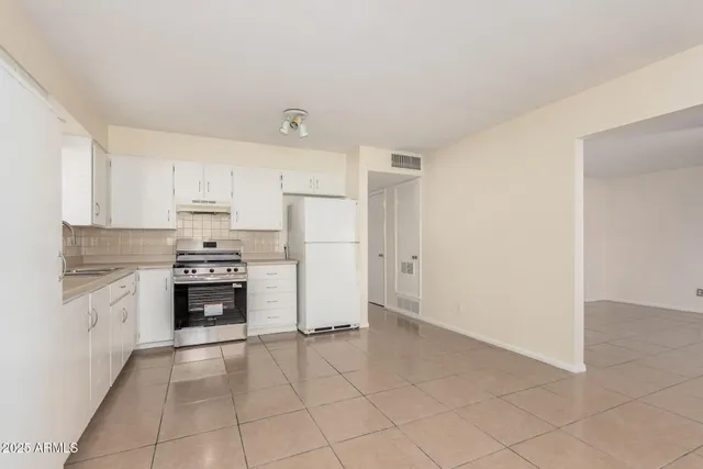 a kitchen with granite countertop a refrigerator and a stove top oven