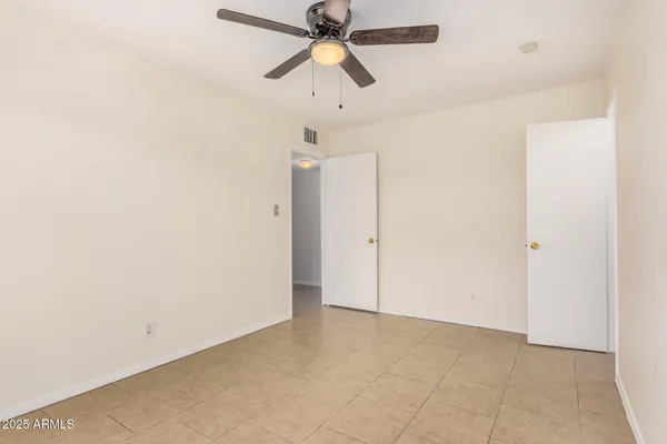an empty room with chandelier fan