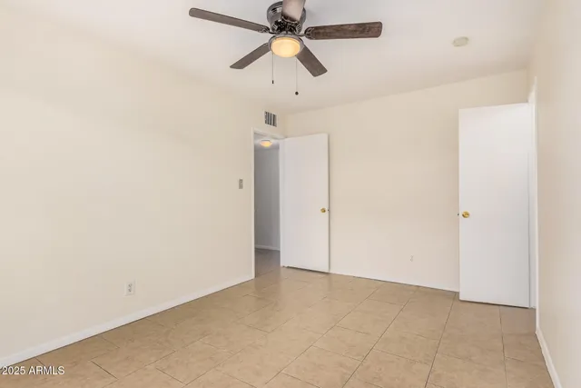 an empty room with chandelier fan