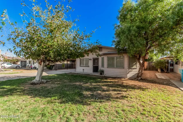 a view of a house with a tree in the yard