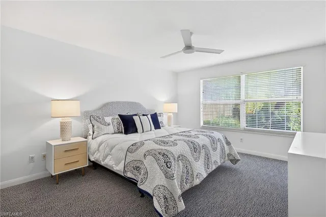 a spacious bedroom with a bed couch and window