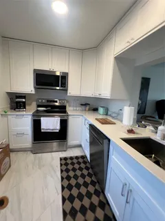 a kitchen with a sink stove top oven and cabinets