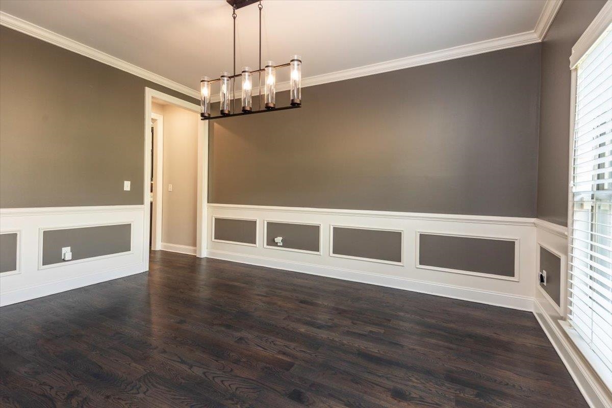 3328 Straw Bridge Road Olive Branch, MS 38654 - Photo 7 of 28 Wood-finish flooring, wainscoting with decorative trim, crown molding, and a multi-light linear chandelier