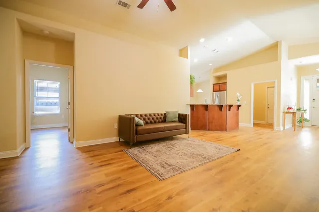 a living room with furniture and a wooden floor