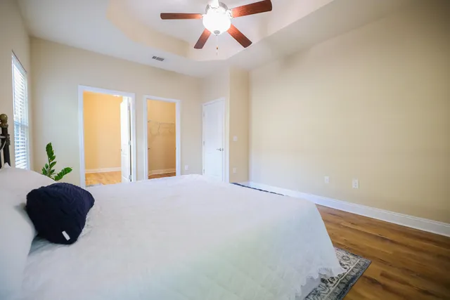 a bedroom with a bed and wooden floor
