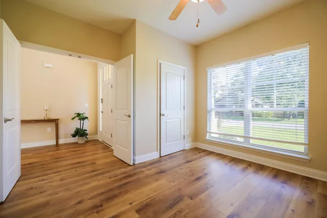 a view of a livingroom with wooden floor and a large window