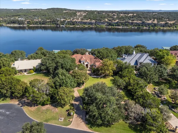 an aerial view of ocean and residential houses with outdoor space