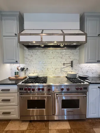 a stove top oven sitting inside of a kitchen
