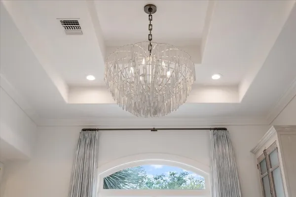 a room with a chandelier and fireplace