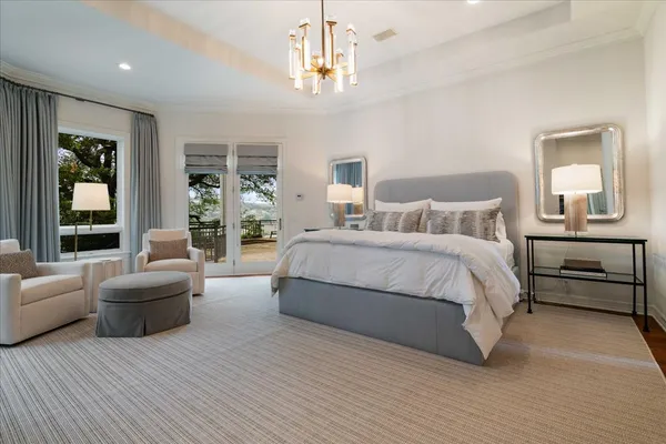 a spacious bedroom with a bed couch and windows