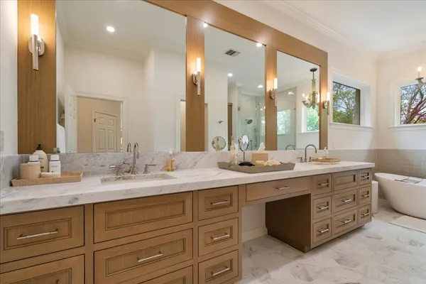 a spacious bathroom with a granite countertop double vanity and mirror