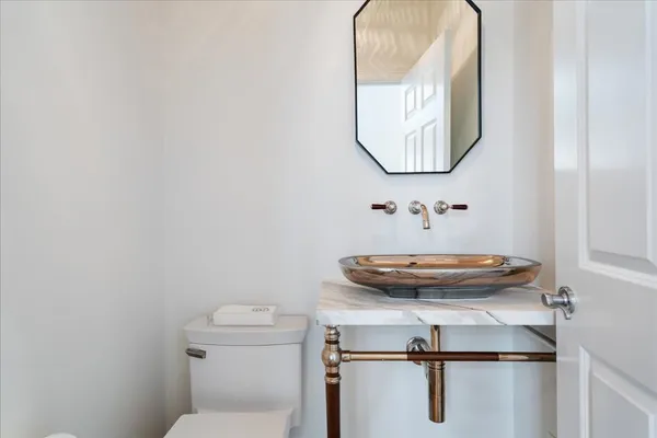 a bathroom with a toilet a sink and mirror
