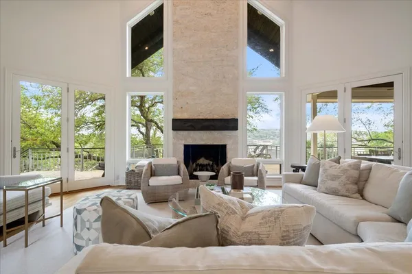 a living room with furniture a large window and a fireplace