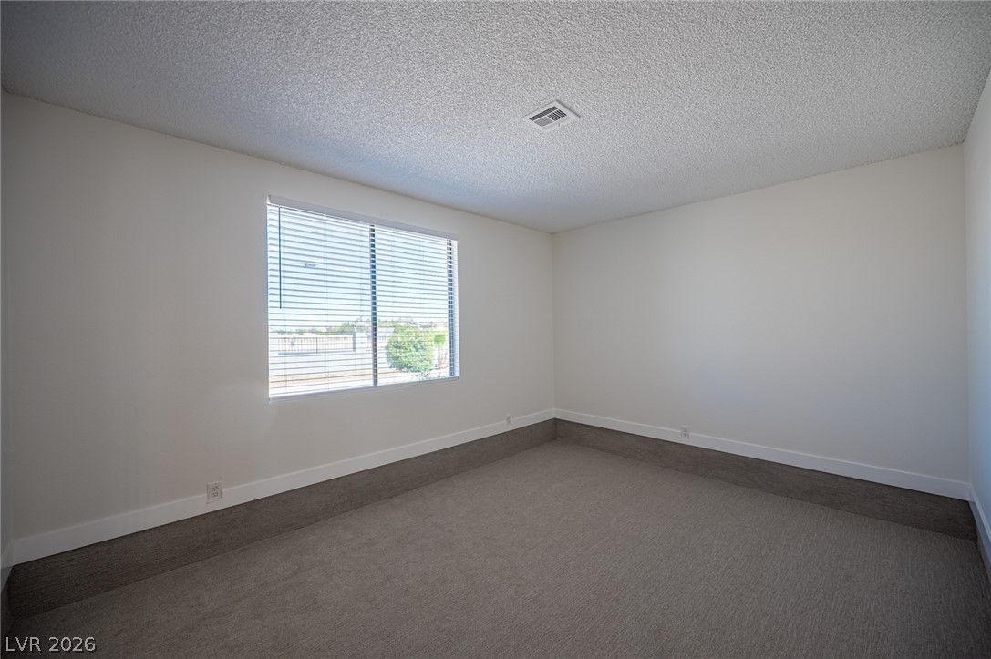 7041 North Decatur Boulevard Las Vegas, NV 89131 - Photo 21 of 33 A spacious room offers ample natural light and plush carpeting.