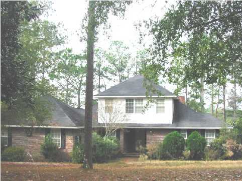 2642 Spring Lake Road DeFuniak Springs, FL 32433 - Photo 2 of 8 a front view of a house with a garden and tree