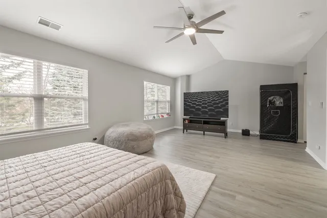 a bedroom with a bed and a large window