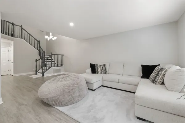 a bedroom with a bed couch and wooden floor